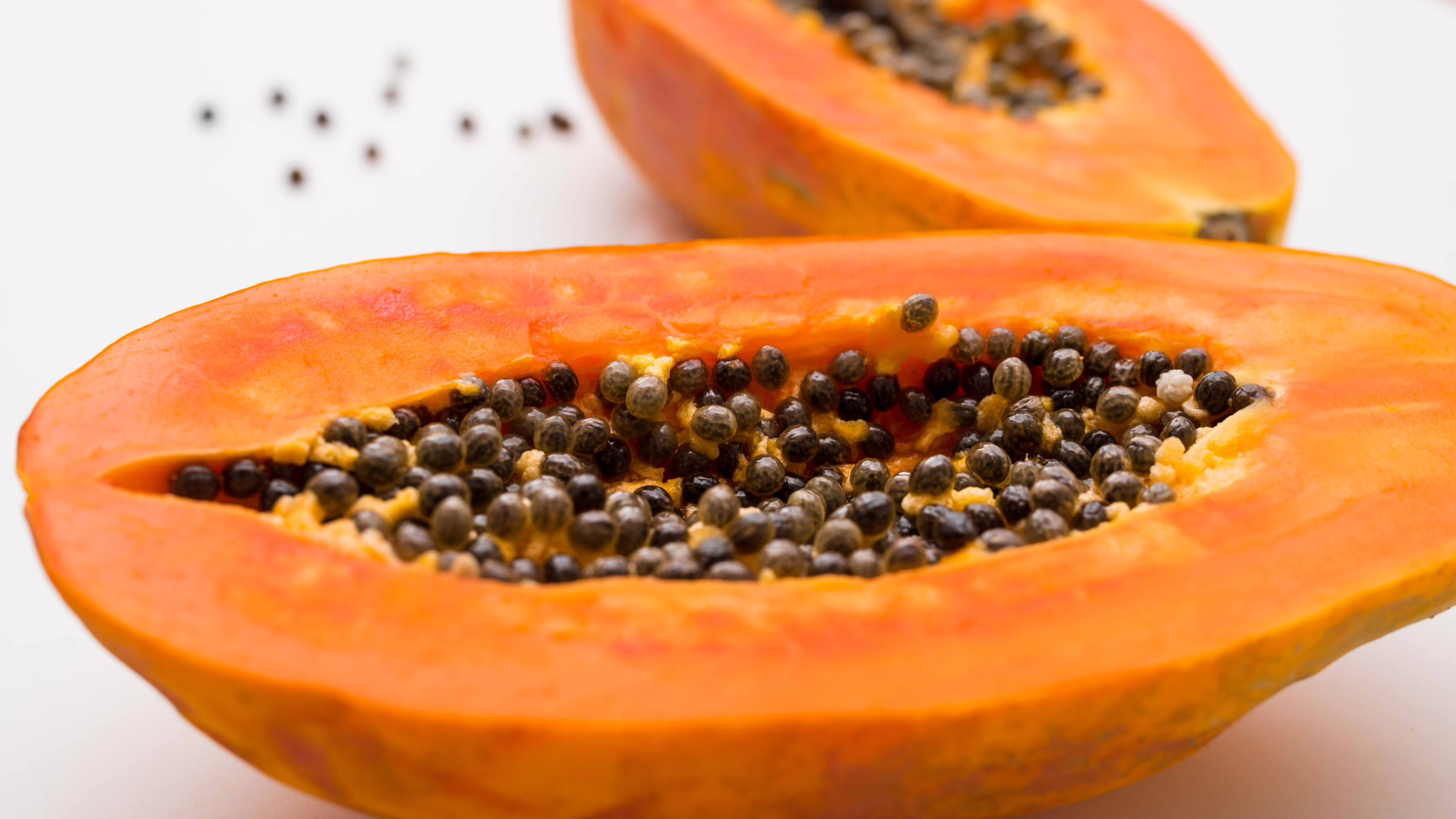 Papaya cut in half on a white background.